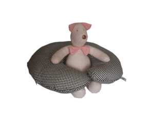 almofada de amamentar branca de bolinhas pretas com porquinho de pano rosa de bolinhas brancas sentado no centro