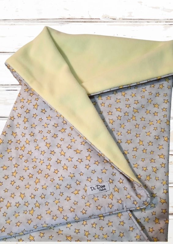 manta de bebê dobrada, um lado em cinza com estampa de estrelinhas amarelas e um lado em soft amarelo
