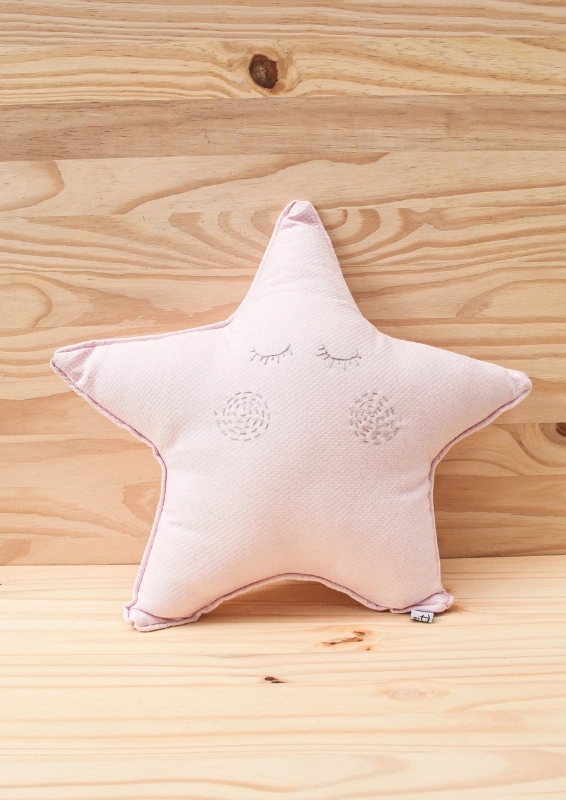 almofada em formato de estrela em rosa claro com rostinho bordado à mão